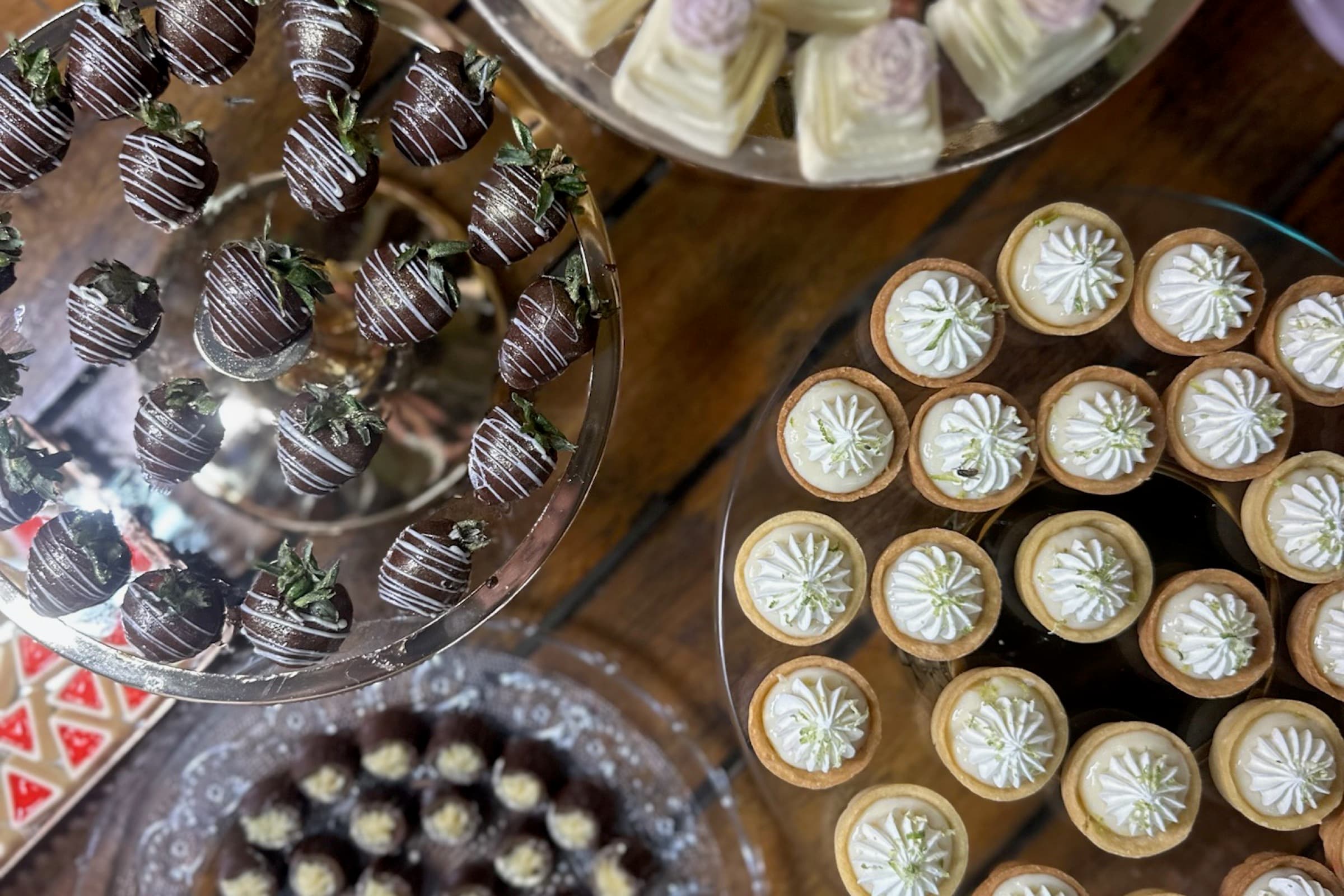 Mini-bolos de casamento brancos em bandeja dourada rendada