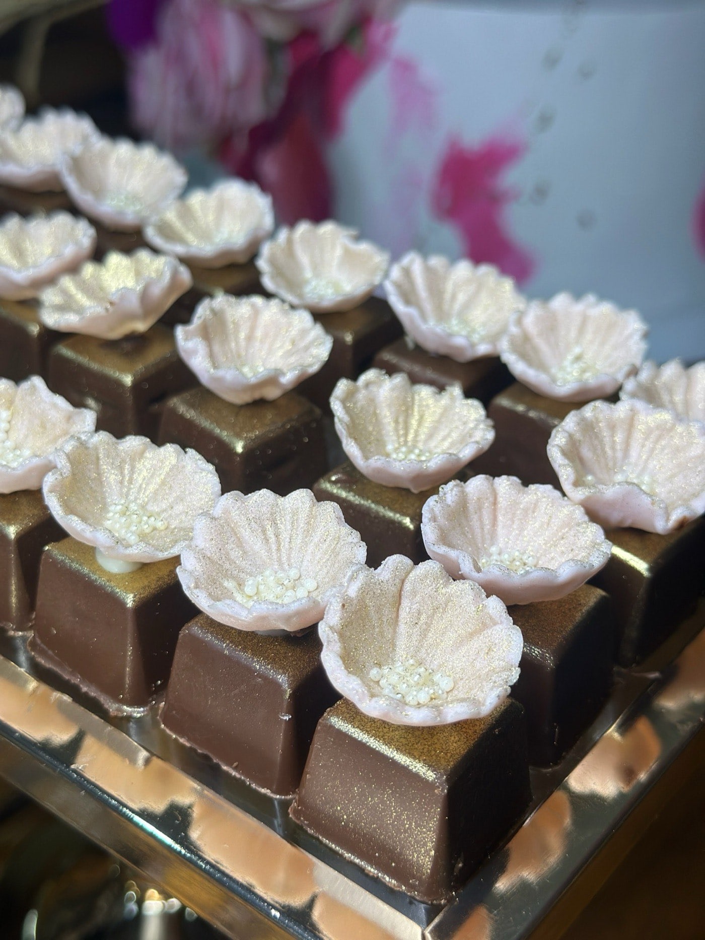 Chocolates nobres dourados com flores brancas de açúcar — linha Doces Finos da Lala